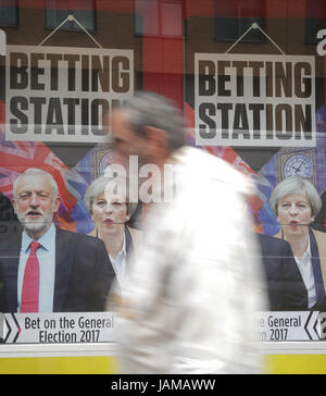 Ein Mann geht Vergangenheit ein Wettbüro mit einer allgemeinen Wahlen Förderung im Fenster in London, als die Staats-und Regierungschefs Großbritanniens größten Parteien sind quer durch das Land in einen Wirbelwind Last Minute-Angebot für Stimmen vor allgemeinen Wahltag am Donnerstag. Stockfoto