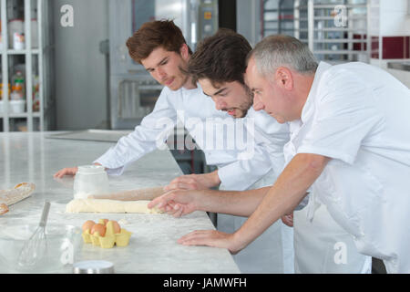 Ausbilder in der Bäckerei Lehre Lehrling, wie zu einem Teig verkneten Stockfoto