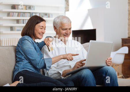 Älteres Paar mit Laptop verbunden und Online-shopping Stockfoto