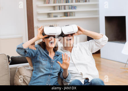 Älteres Paar mit virtual-Reality-Kopfhörer im Wohnzimmer Stockfoto