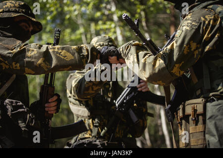 drei Soldaten Händeschütteln in Wäldern bei Tag Stockfoto