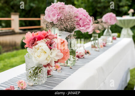 Blumen-Einstellungen Dekoration im freien Setup für eine Hochzeit mit rosa farbigen Blume Stockfoto