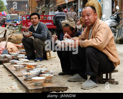 ZHAOXING, CHINA - 11. November 2010: Bewohner der Zhaoxing ist eine hübsche Dong Minderheit-Stadt auf der High Street auf der gemeinsamen Mahlzeit essen Stockfoto