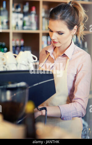 Kellnerin mit Kaffeemaschine bei der Arbeit Stockfoto