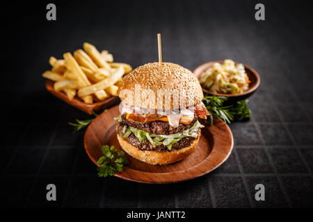 Frische leckere Burger auf dunklem Hintergrund Stockfoto