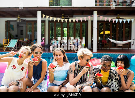 Gruppe von unterschiedlichen Frauen sitzen am pool Stockfoto