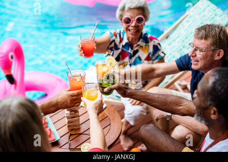 Gruppe von diversen senior Erwachsene genießen Getränke am Pool zusammen Stockfoto