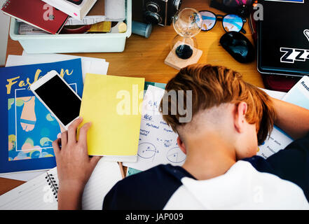 Kaukasischer Junge fiel einen Schlaf während der Hausaufgaben Stockfoto