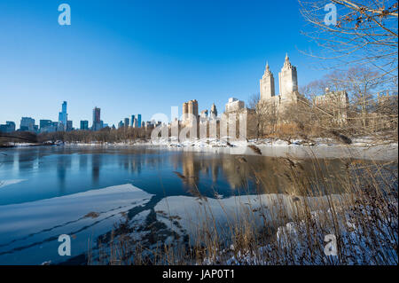 Malerische Aussicht auf die Upper West Side-Skyline reflektiert im Eis der zugefrorenen Central Park-See nach einem Winter Schneesturm in New York City Stockfoto