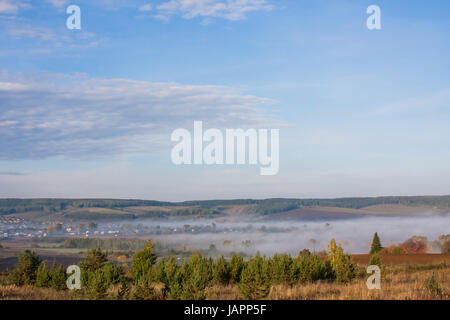 Perm, Russland - Nebel über dem Dorf in den frühen Morgenstunden Stockfoto