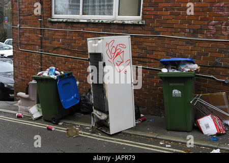 Müll überfüllt und am Straßenrand, einschließlich einen Kühlschrank mit Gefrierfach und einen Stuhl geworfen. Stockfoto