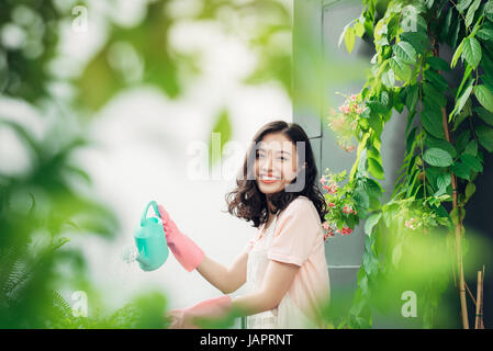Junge asiatische Frauen Gärtner die Pflanzen gießen Stockfoto