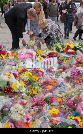 Menschen legen Blumen Angebote auf dem Bürgersteig von London Bridge, wo Menschen wurden getötet und verwundet in einem terroristischen Anschlag in der Nacht vom 3. Juni 2017.London,UK Stockfoto