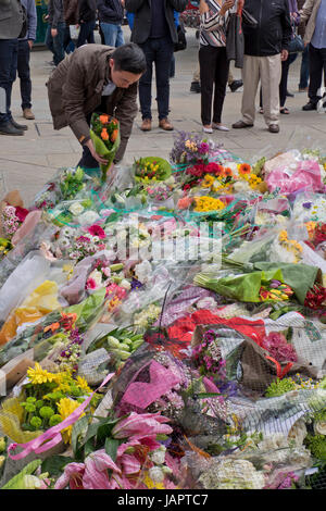 Menschen legen Blumen Angebote auf dem Bürgersteig von London Bridge, wo Menschen wurden getötet und verwundet in einem terroristischen Anschlag in der Nacht vom 3. Juni 2017.London,UK Stockfoto