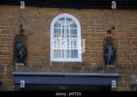 Das Saracens Head, Towcester, Northamptonshire, stammt aus dem sechzehnten Jahrhundert.  Es hat eine lange Eisenstein Front mit Statuen von Venus und Apollo auf ei Stockfoto