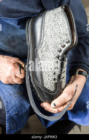Schuhmacher, Hand Schneide des aufgeklebten Außensohle mit Messer, Kainisch, Steiermark, Österreich Stockfoto