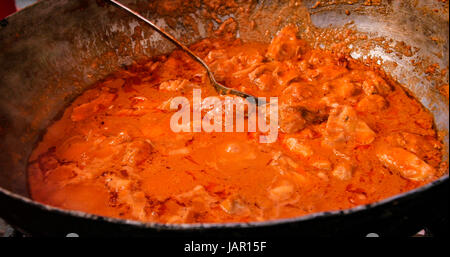 Kochen einen leckere Fleisch-Eintopf mit Tomatensauce in einem großen wok Stockfoto