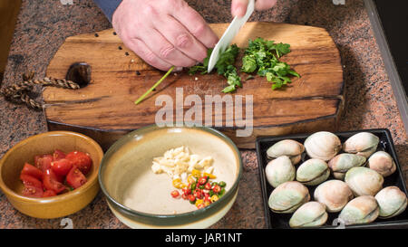 Schneiden Petersilie Zubereitung Zutaten für leckere Spaghetti Alle Vongole (Venusmuscheln) Stockfoto