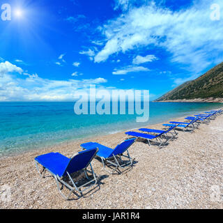 Sommer sonniger Kieselstrand mit blauen Himmel und Liegestühle am Strand (Albanien). Zwei Schüsse feststeppen Bild. Stockfoto