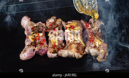 Kochen leckere klebrige geschmorte Schweinerippchen, Gießen Honig König Stockfoto