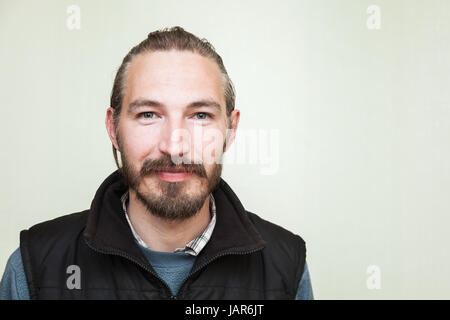Closeup Studioportrait lächelnder junge bärtige asiatischen Mann über leichte grüne Wand Hintergrund Stockfoto