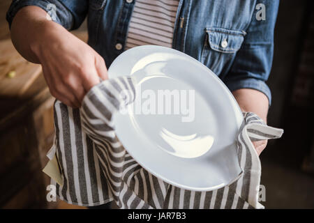 Frau wischte Platte Stockfoto