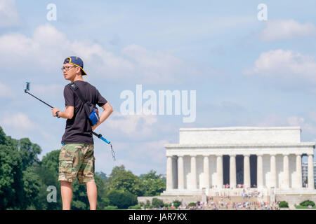 Junger Mann mit einem Selfie-Stick mit dem Lincoln-Memorial im Hintergrund Stockfoto