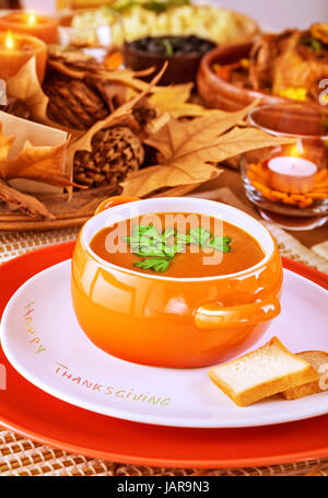 Leckere Suppe am schön gedeckten Tisch mit Kerzen und herbstliche Laub, festliches Dinner zu Hause Thanksgiving Day Konzept Stockfoto