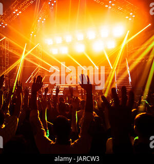 Foto von jungen Menschen, die Spaß am Rock-Konzert, aktiven Lebensstil, Fans applaudieren berühmte Musikgruppe, Nachtleben, dj auf der Bühne im Club, auf der Tanzfläche, Nacht Perfomance tanzende Menge Stockfoto