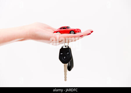 Auto-Kauf-Konzept. Spielzeugauto auf Frau Palm, Autoschlüssel am finger Stockfoto