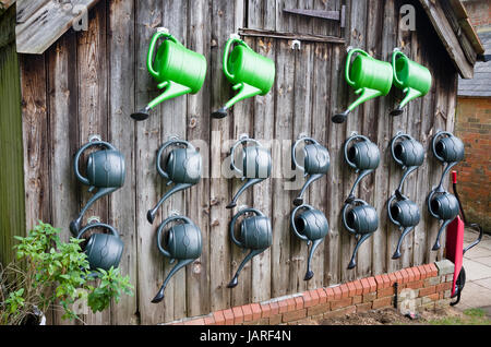 An einem Werktag außerschulische lagern die Gießkannen fein säuberlich auf das Ende der alten Gebäude im Königreich Stockfoto