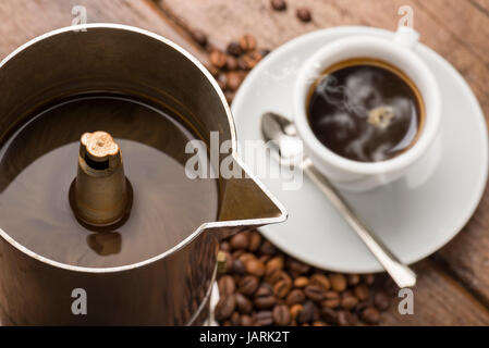 Nahaufnahme der Kaffeekanne und Tasse Kaffee auf Holztisch Stockfoto