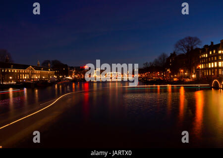 Spuren des Lichts auf eines der großen Grachten in Amsterdam bei Nacht Stockfoto