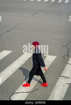 Ältere Frau beim Überqueren der Straße, Zhongshan Road im Zentrum von Shanghai, China Stockfoto