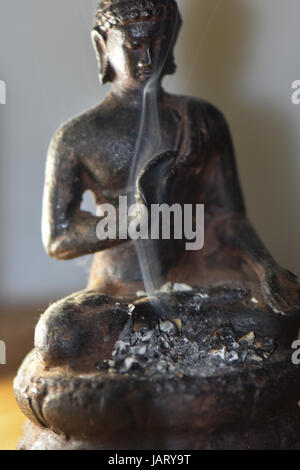 Nahaufnahme der Buddha-Statue mit Rauchen Weihrauch. Stockfoto
