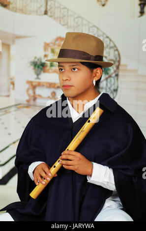 Porträt von hübschen jungen indigenen Mann aus Otavalo, Ecuador, Quena Flötenspiel hautnah Stockfoto