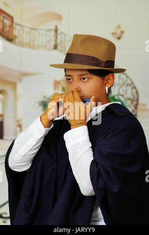 Porträt von hübschen jungen indigenen Mann aus Otavalo, Ecuador, die Mundharmonika spielen hautnah Stockfoto