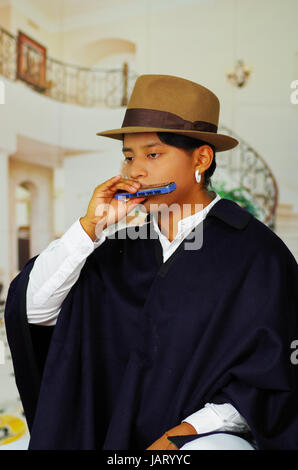 Porträt von hübschen jungen indigenen Mann aus Otavalo, Ecuador, die Mundharmonika spielen hautnah Stockfoto