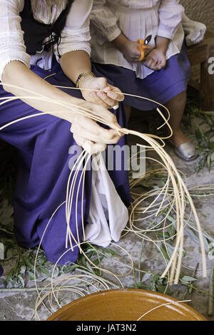 Nähende Frau in Uniform Stühle mittelalterlicher Handwerkermarkt Stockfoto