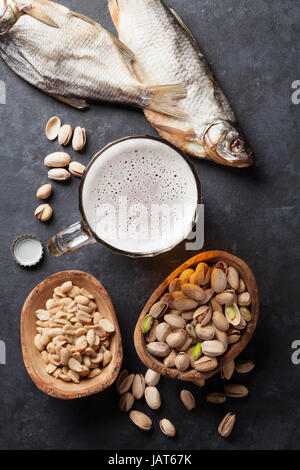 Lager-Bier und Snacks am Steintisch. Muttern, gesalzener Fisch. Ansicht von oben Stockfoto