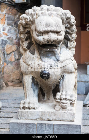 LUOYANG, CHINA - 20. März 2017: steinernen Löwenstatue in der Nähe von Tempel der chinesischen buddhistischen Denkmal Longmen Grotten im Frühjahr. Der Komplex wurde auf eingeschrieben. Stockfoto