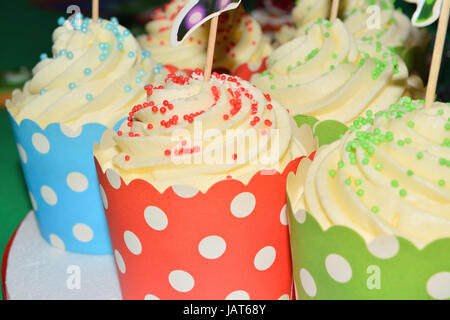 Tasse Kuchen mit Sahne und verschiedene bunte Dekorationen Stockfoto