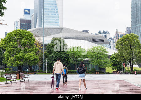 GUANGZHOU, CHINA - 31. März 2017: Menschen auf dem Platz in der Nähe von Opernhaus in Zhujiang New Town of Guangzhou Stadt in regnerischen Tag. Theater wurde von Zaha entworfen. Stockfoto