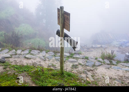 Reisen Sie nach China - Wegweiser auf Bergpfad in nebliger Frühlingstag im Bereich von Dazhai Longsheng Reisterrassen (Dragon es Rückgrat Terrasse, Longji Reis Terra Stockfoto