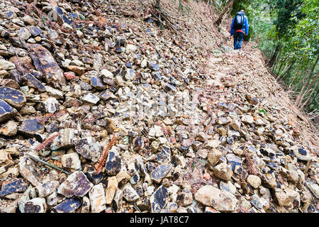 Reisen Sie nach China - touristische Spaziergänge am Weg durch Hangrutsch am Berghang in Dazhai Land von Longsheng Reisterrassen (Dragon es Rückgrat Terrasse, L Stockfoto