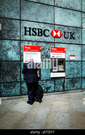 HSBC Geldautomaten Geldautomaten - ein Mann zieht sich Bargeld von einem Geldautomaten bei HSBC-Filiale in Londons Finanzviertel Stockfoto