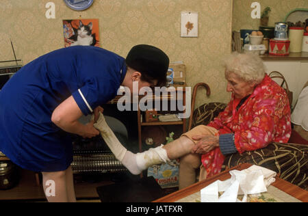 Bezirk Krankenschwester auf einem Haus zu besuchen, eine ältere Frau ulzeriert Bein Reinigung Stockfoto