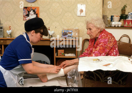 Hilfe im Haushalt Betreuer Bezirk Krankenschwester auf einen Hausbesuch tendenziell Seniorin mit Ulcus cruris Stockfoto