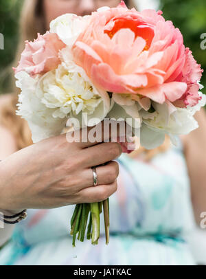Hochzeit Blumenstrauß im Besitz einer Braut-Nahaufnahme. Rosa Blume mit ring Stockfoto