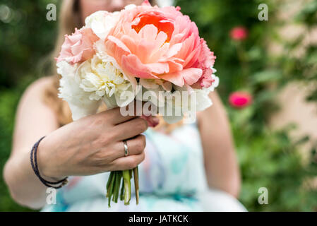 Hochzeit Blumenstrauß im Besitz einer Braut-Nahaufnahme. Rosa Blume mit ring Stockfoto